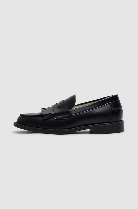 Black loafer shoe on a light gray background