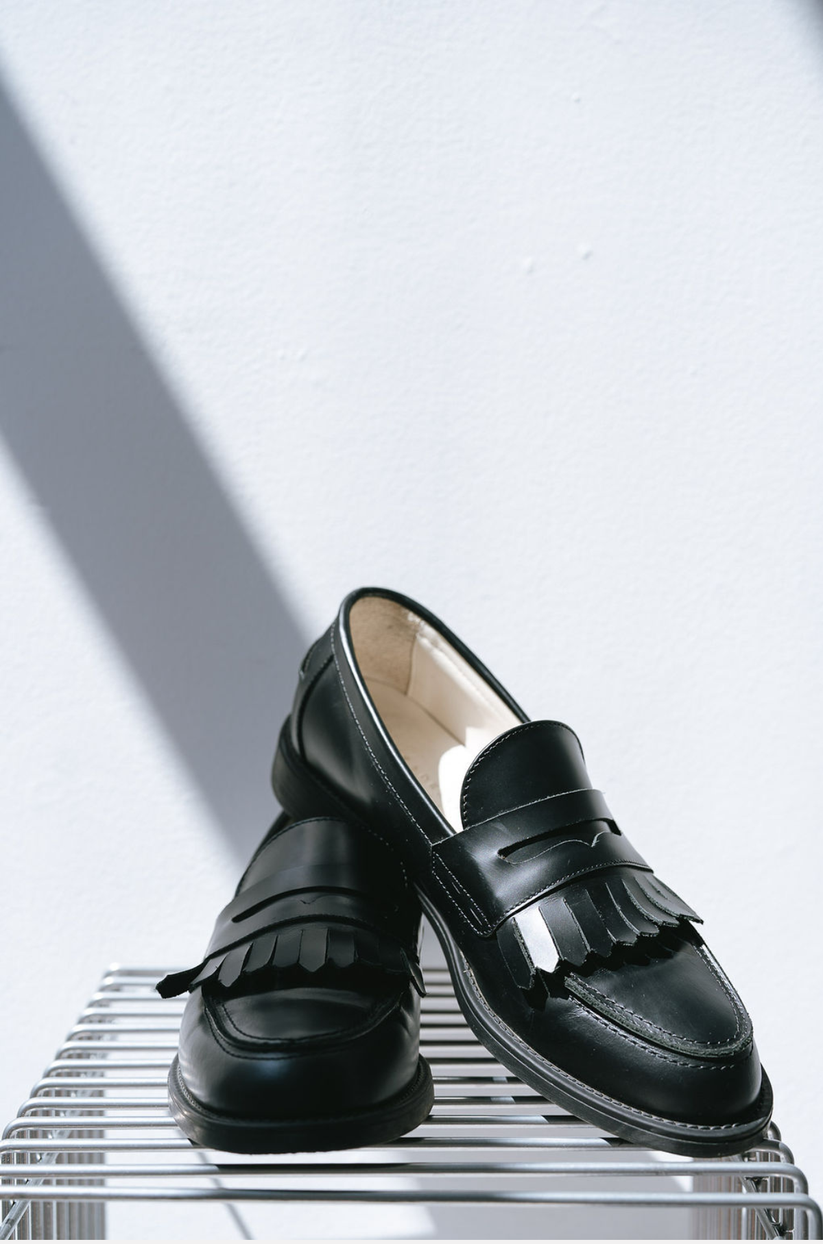 Black loafers with fringes on a white background ith fringes from the duke and dexter brand