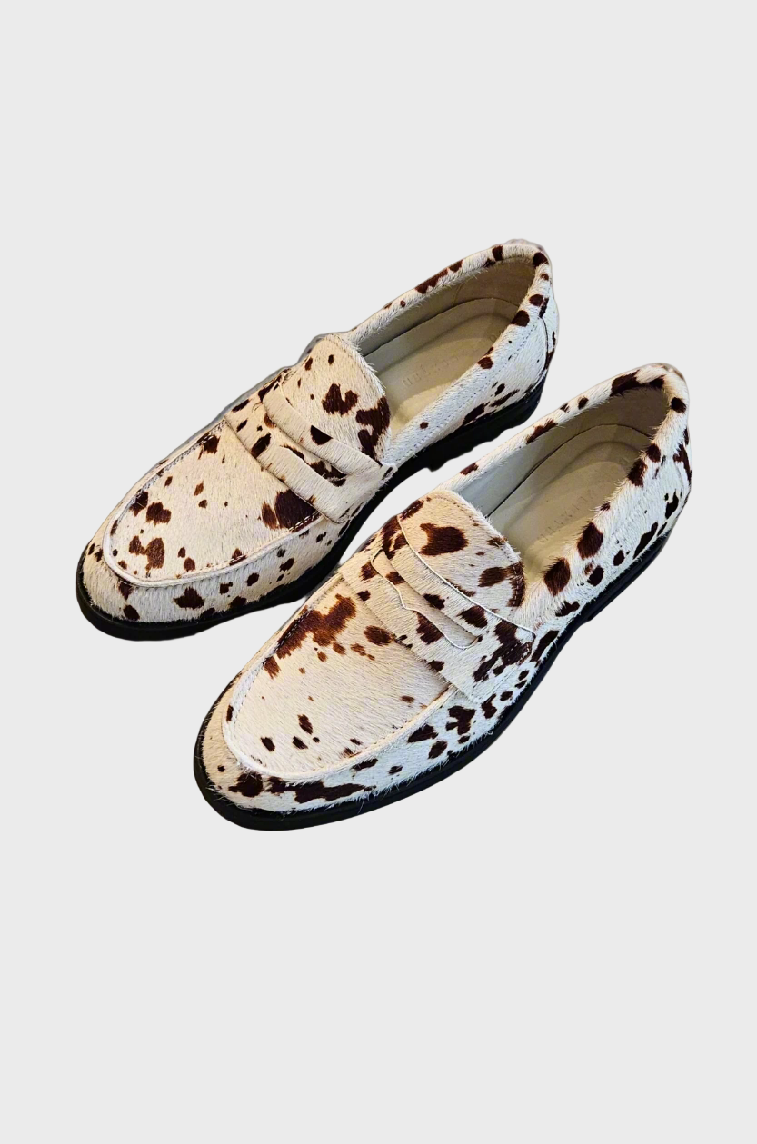 Pair of loafers with a spotted pattern on a concrete surface