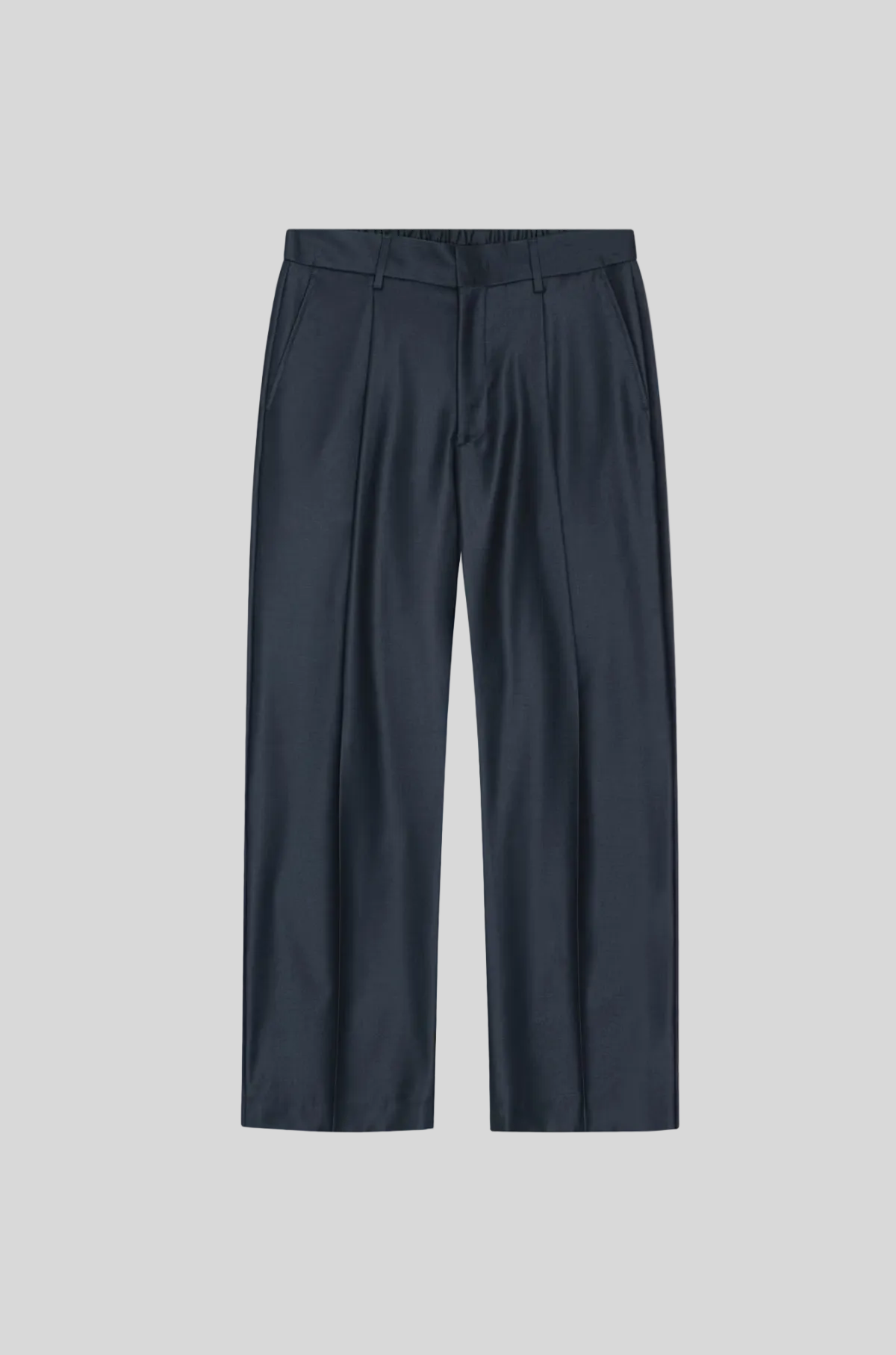 A pair of dark navy blue trousers with a flat front and subtle vertical creasing, displayed flat against a solid light beige background.